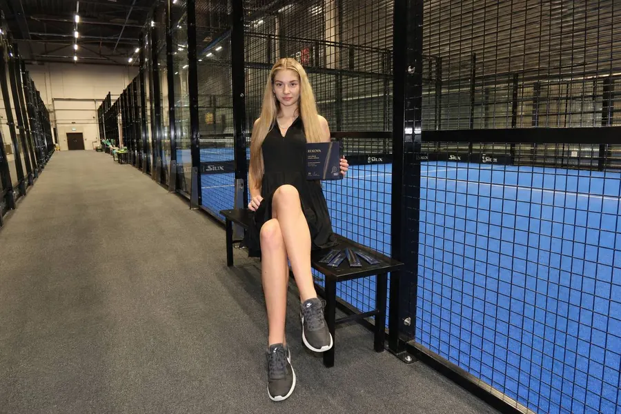 Padel player on a bench with Rekova sachets beside her
